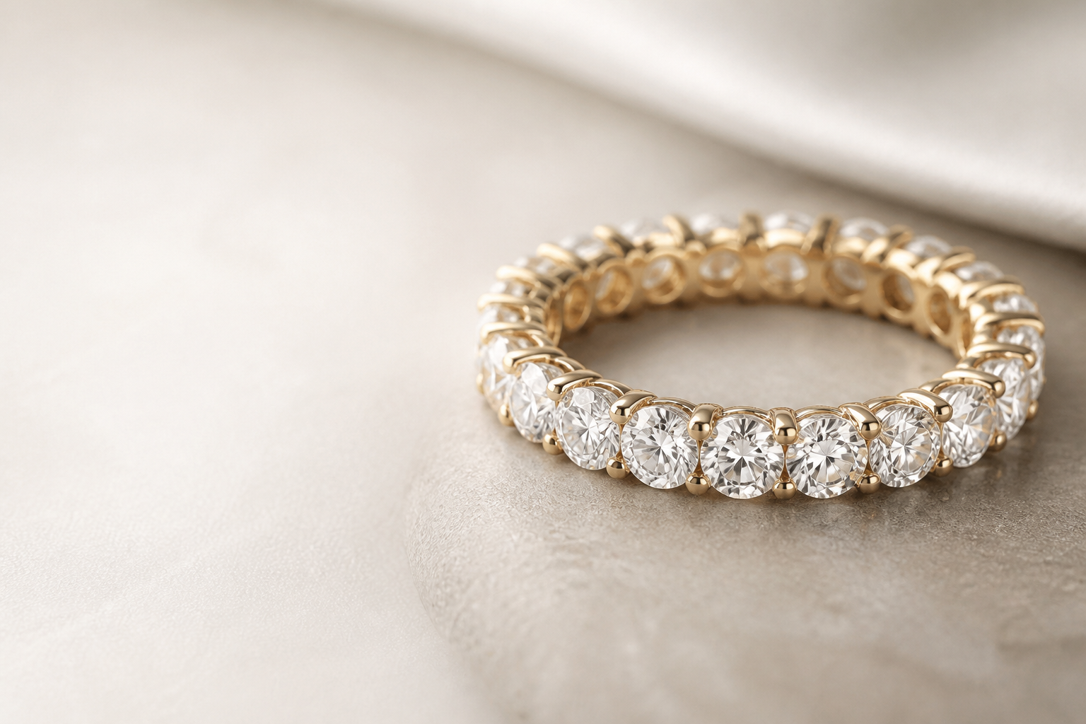 Gold diamond eternity band on a jeweller's hand